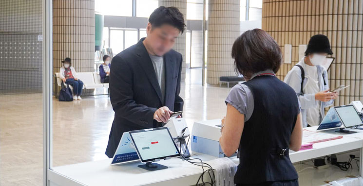 アクト中食展示会FOOD & BEVERAGEの会場入口で来場者が2次元コードを表示して受付をしている風景