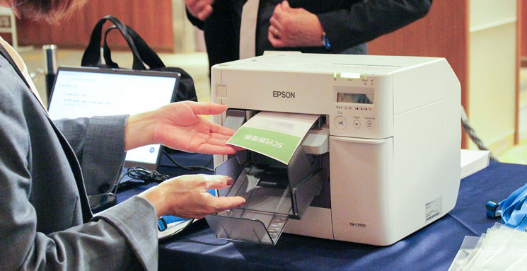 イオン同友店会総会で展示会受付で入場証が印刷されている様子
