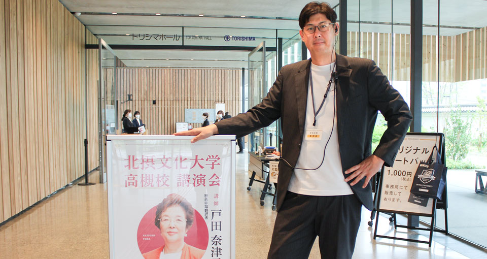 入場受付口に立つ池谷様の写真