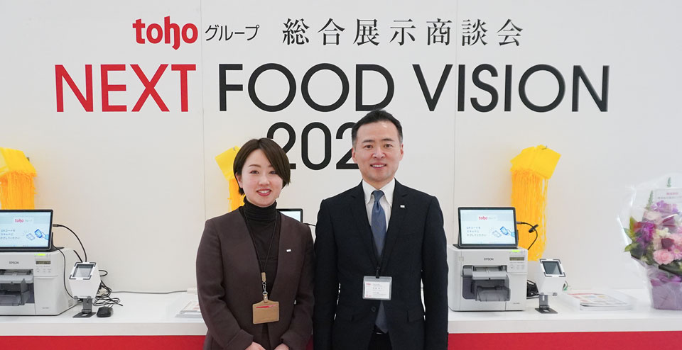 tohoグループ 総合展示商談会の受付前に立っている株式会社トーホー廣瀬様、神谷様